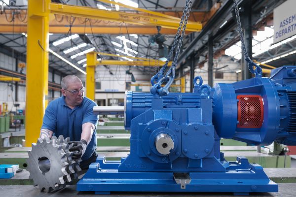 Engineer assembling industrial gearbox in engineering factory